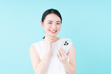 スマホでサロン予約をする若い女性