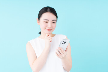 スマホでサロン予約をする若い女性