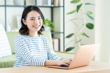 リビングでパソコンを使う若い女性