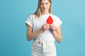 Blood donation, medicine and awareness concept. Beautiful woman holding red blood drop mockup in...