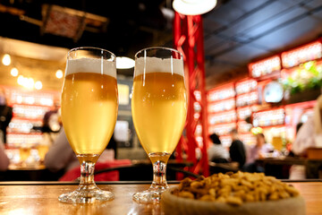 Beer glasses with beer and nuts on a blurred background of a beer bar.