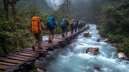 Group of backpackers crossing a wooden bridge over a rushing river in lush, green forest environment.