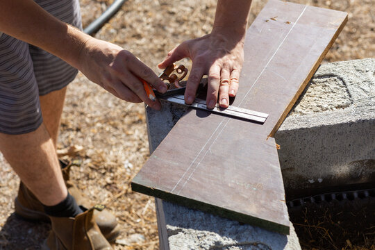 Handyman measuring chipboard for diy project