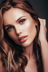 Fototapeta premium Fashion beauty portrait of young brunette woman with evening stylish makeup and perfect clean skin. Sexy model with curly hairstyle posing in studio
