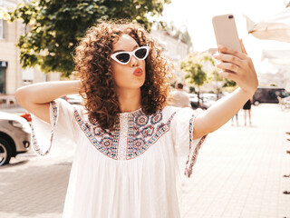 Beautiful smiling model with afro curls hairstyle dressed in summer hipster white dress. Carefree...