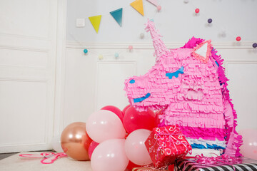 Bright party decor feature cheerful unicorn pinata and balloons