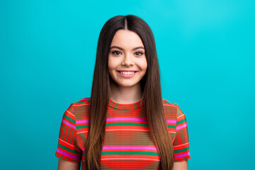 Fototapeta premium Portrait of a young woman in a colorful striped shirt smiling against a vibrant teal background, showcasing happiness and modern style