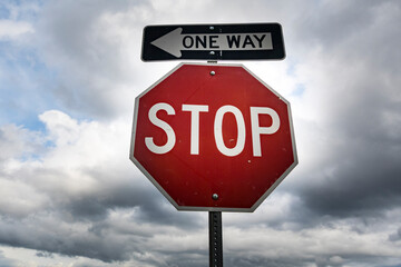 Red stop sign with One Way sign attached