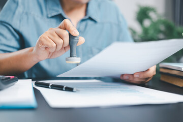 Businessman hands stamp approve on financial business approval document paper. Man hand accepted...