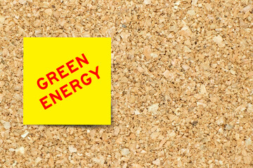 Yellow note paper with word green energy on cork board background with copy space
