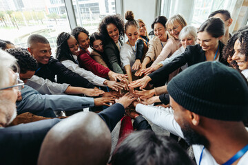 Corporate team with hands united celebrating success and teamwork in modern office environment
