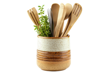 A charming collection of wooden kitchen utensils and fresh herbs in a speckled ceramic holder evoking rustic simplicity isolated on black background.
