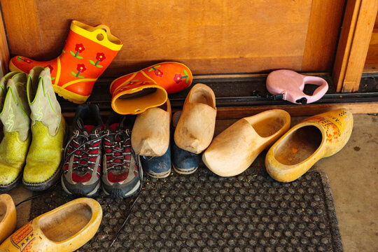 Family's shoes on door mat by a doorway into the home. 