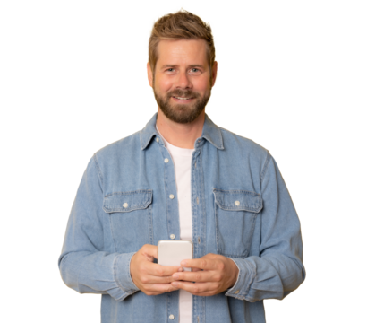 Young handsome man holding smartphone in hands wearing denim shirt, looking at camera with positive smile isolated over transparent background. PNG transparent.