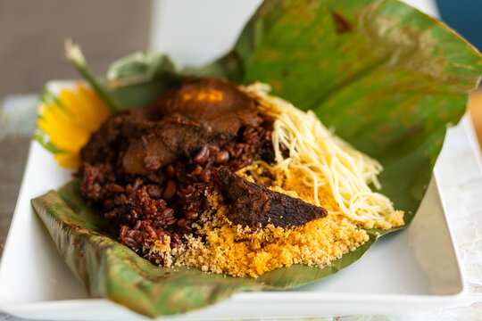 Waakye, local Ghana food made with rice and beans served spaghetti, egg, wele and gari on plantain leaves.