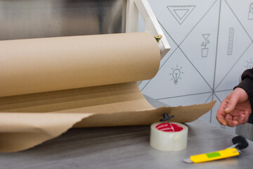 A man cuts kraft paper for packing goods in a store.