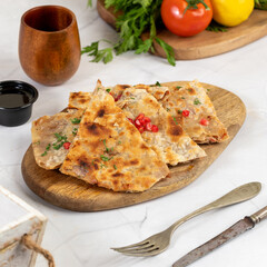 Delicious flatbread with pomegranate and herbs on a wooden board