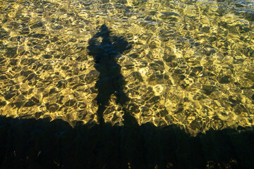Shadow of a photographer on the clear waters of Lake Tahoe, High Sierra