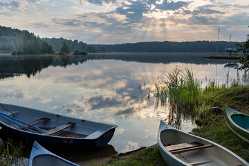Obraz premium A group of small boats are sitting on the shore of a lake