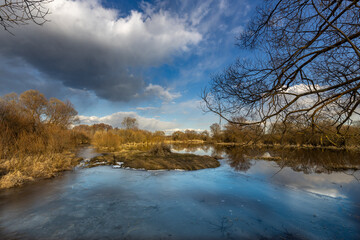 A lake with a cloudy sky in the background