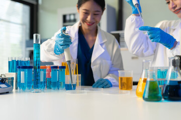Scientist analyzing and dropping a sample into a glassware.
