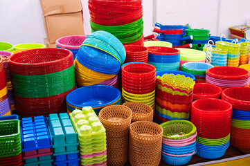 Close-up view of a vibrant stack of plastic bowls and baskets at a market.