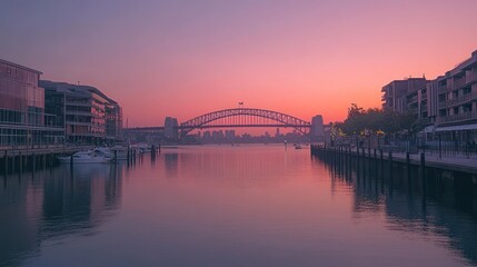Sunrise over harbor with bridge.  Calm waters reflect the vibrant sky