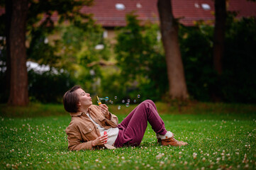 Relaxed Adult Blowing Bubbles While Lying in Park