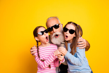 Joyful Three Generational Portrait with Bright Yellow Background Captures Family Bonding and...