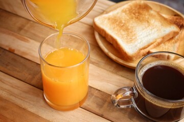 Breakfast of orange juice summer drink and black coffee  toast bread