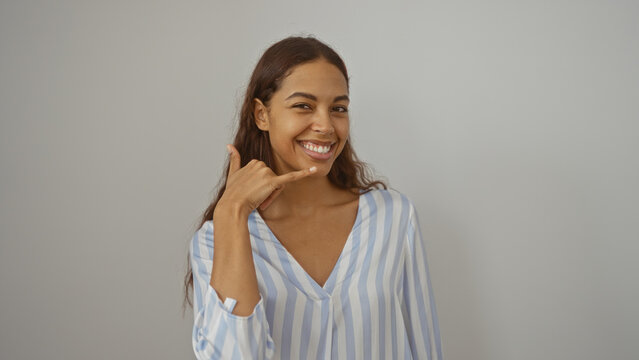 Woman making phone gesture with hand smiling on isolated white background over wall, young african american person brunette beautiful latin hispanic