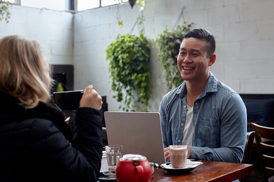 Man enjoying time with friend over coffee at cafe
