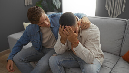 Man comforting distressed friend in apartment living room highlighting supportive friendship...
