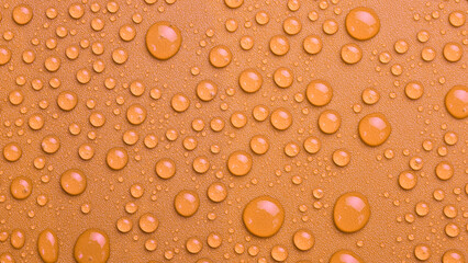 Close-up Drops of water on a yellow-gold background. Macro photo. Top view.