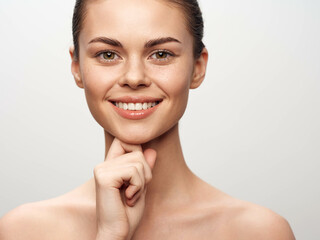 Happy and Beautiful Young Woman Posing with Hand on Chin and Looking at Camera in Studio Portrait...