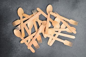 Wooden cutlery. The concept of environmental protection. On a gray stone background, top view.