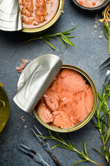 A metal can with tuna in oil. Food stocks. On a gray concrete background.
