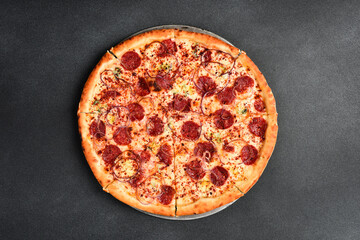 Italian pizza with pepperoni salami. Top view. Free space for text. On a gray stone background.