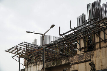 Construction Site with Steel Scaffolding and Unfinished Building Under Grey Overcast Sky