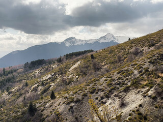 Hikers explore the diverse terrain of Mavrovo National Park in Galichnik, North Macedonia, surrounded by stunning mountains and rich natural beauty on a cloudy day