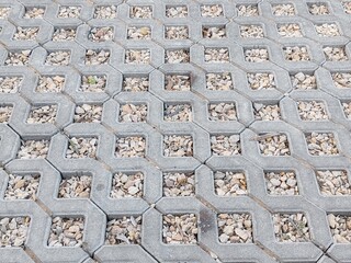 Concrete Cement Pavers with filling Gravel Stones inside in Parking lot. 
Small Interlock Tiles concrete Grass Pavers in design pattern.
Interlock tiles for Parking Cars and flooring purpose