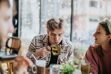 A group of friends seated at a table in a cozy cafe, enjoying warm beverages and engaging in lively conversation, framed by a background of twinkling fairy lights and a relaxed atmosphere.
