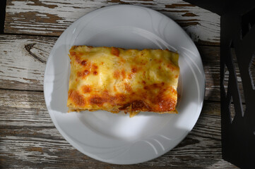 Deliciously baked layered casserole on a white plate showcasing golden cheese and inviting aroma
