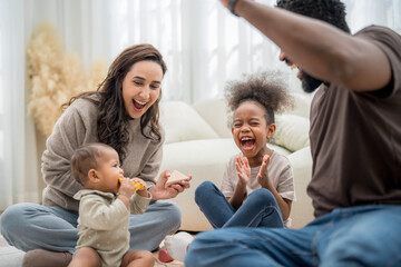 Family enjoys fun playtime indoors in a bright living room full of joy and laughter with children and parents