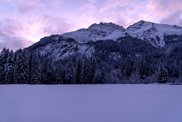 Winter scenery at sunset with snow-covered nature in the Bavarian Alps, Germany