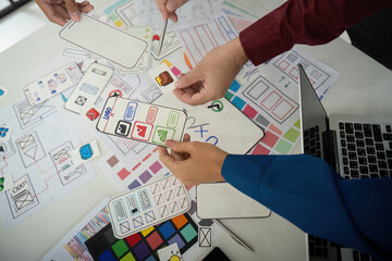 Team Coordination and Idea Exchange. Designers sharing layouts and feedback in an interactive session for UI design.