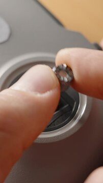 Vertical video. Person Rotating and Controlling Metal Stick on FPV Drone Joystick with Fingers in Close-Up View on Wooden Surface, Macro Shot, Manual Control Concept