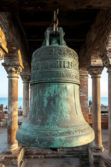 Fototapeta premium Large, old, weathered bell, hanging in architectural structure near the ocean