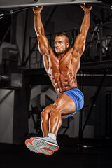 Muscular Man, Bodybuilder doing Hanging Leg Raises , Abdominal Muscle Exercise