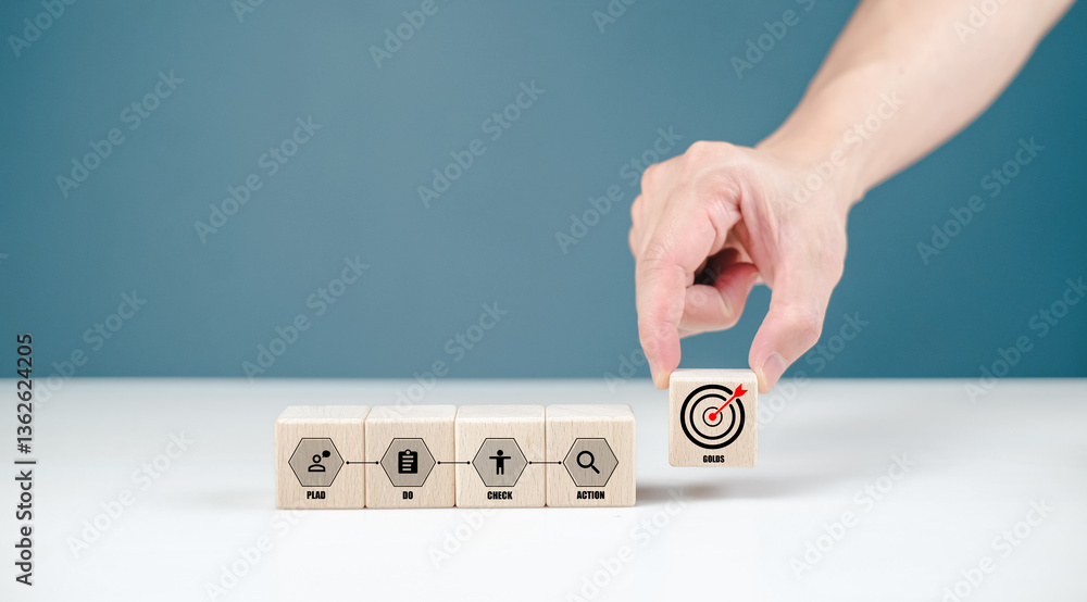 Poster a hand is placing a block with a target icon among others, symbolizing focus and goal-setting in a m
